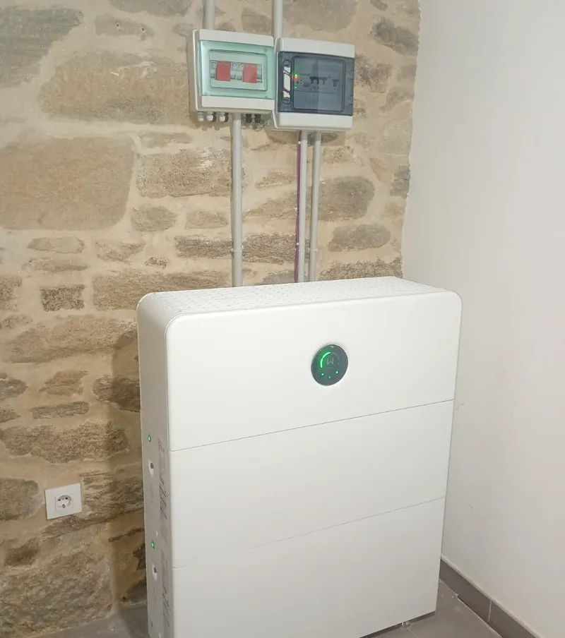 Batería modular de tres módulos junto a pared de piedra