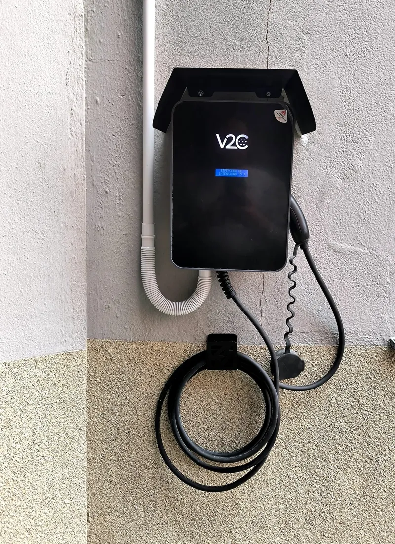 Cargador de vehículo eléctrico con visera y soporte para recoger el cable
