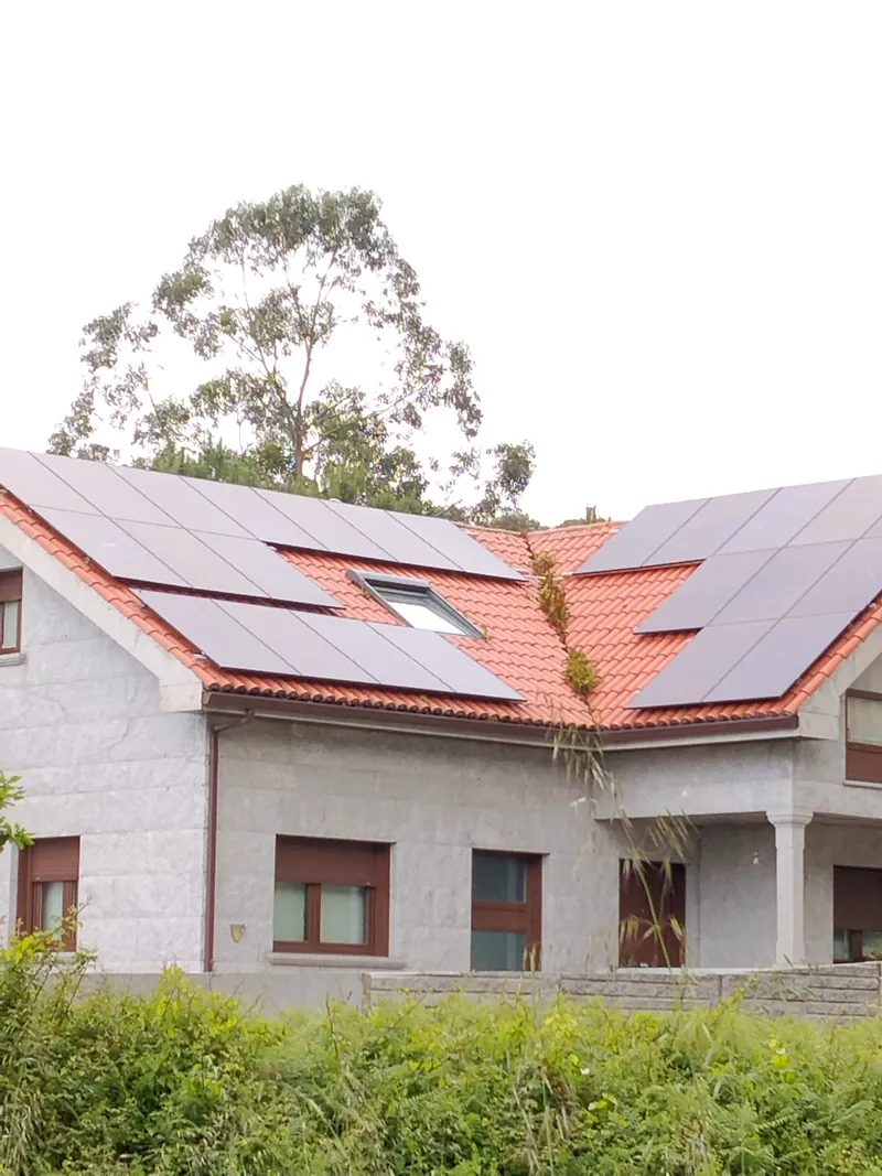 Casa de granito con paneles solares alrededor de un lucernario