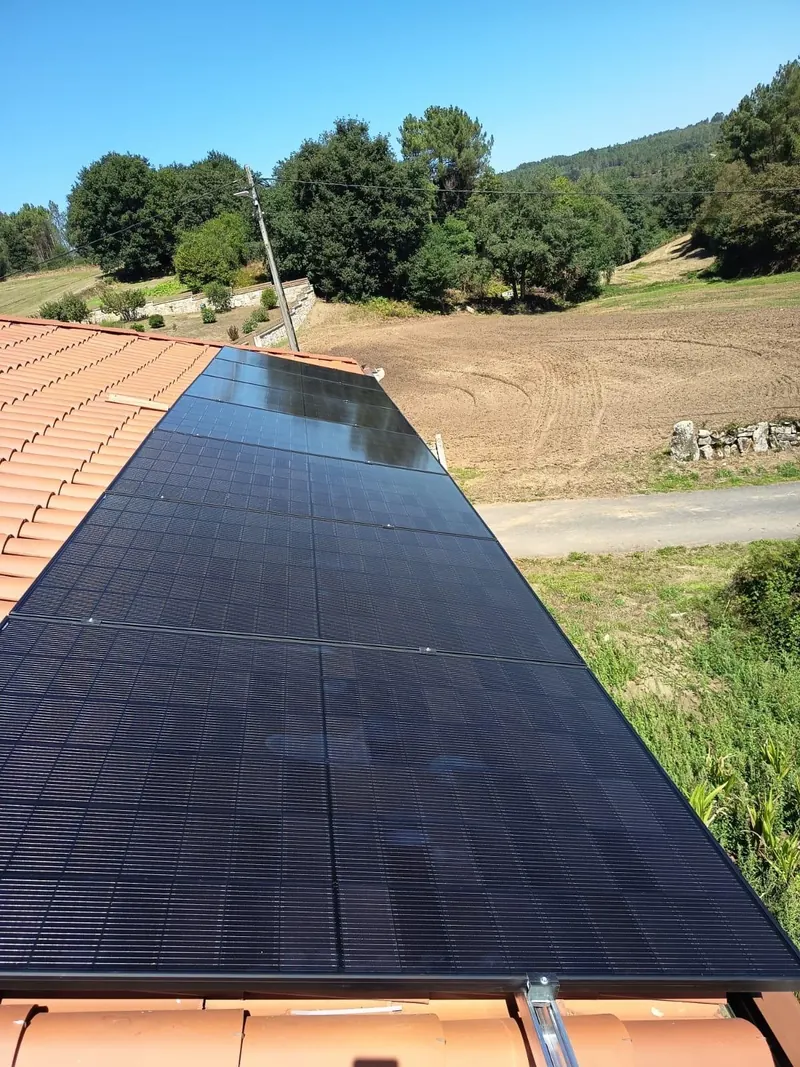 Fila de paneles solares fotovoltaicos sobre un tejado de teja