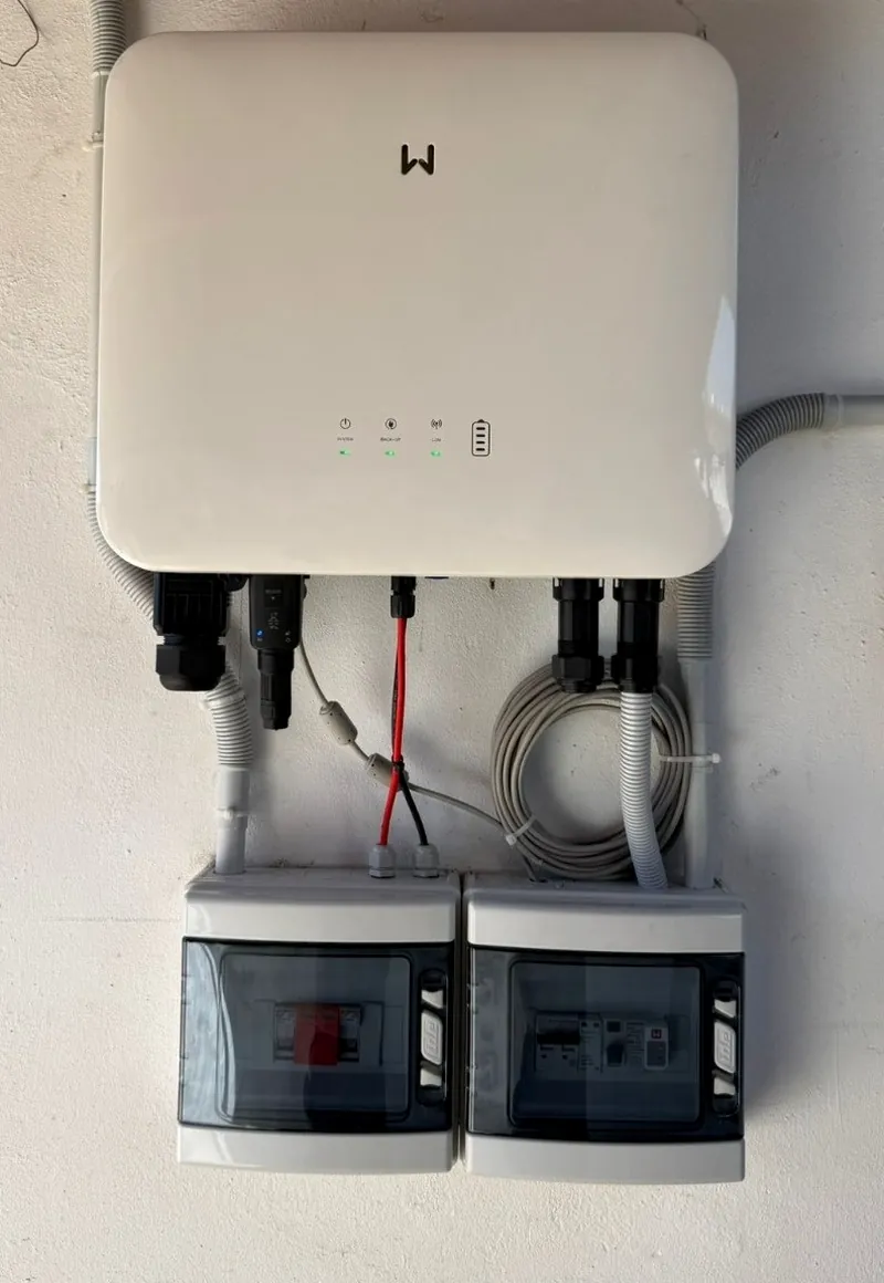 Inversor híbrido solar instalado en pared con cuadros de protección