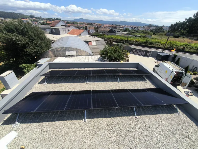 Paneles solares sobre cubierta plana con estructura metálica y grava