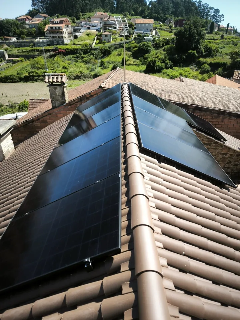 Paneles solares a ambos lados de la cumbrera con vistas a la ladera
