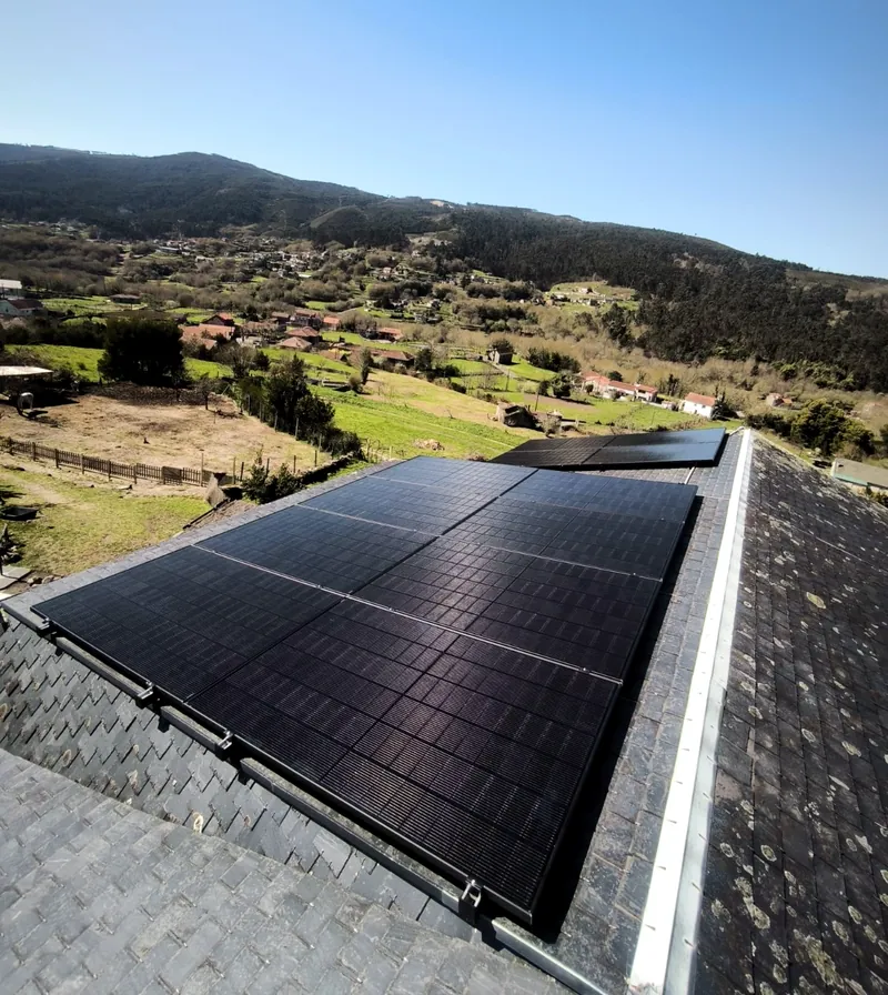 Paneles solares sobre cubierta de pizarra con vistas al valle